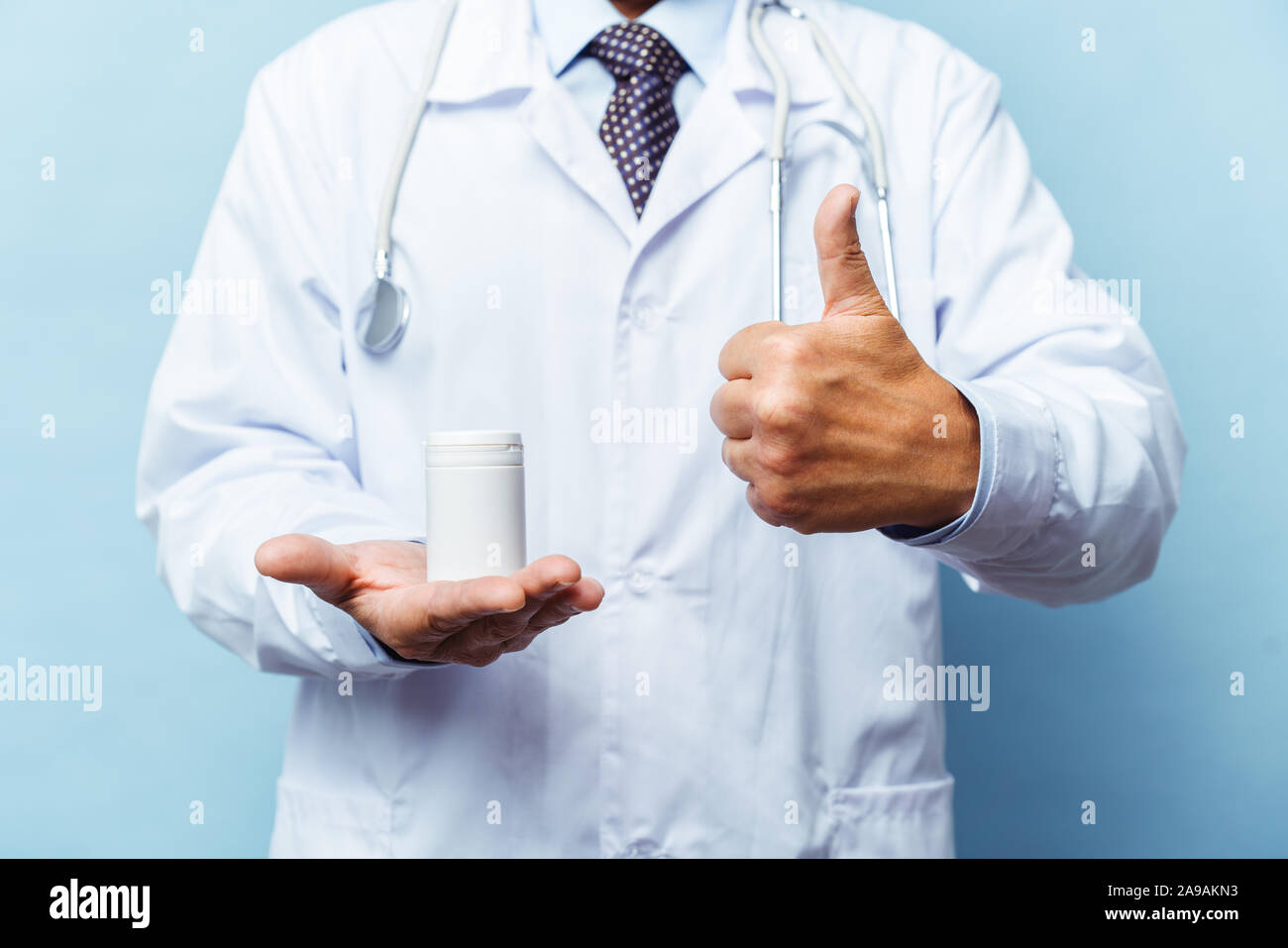 Medico tenendo una bottiglia di pillole su sfondo bianco. Il concetto di medicina, farmacologia, healthcare Foto Stock