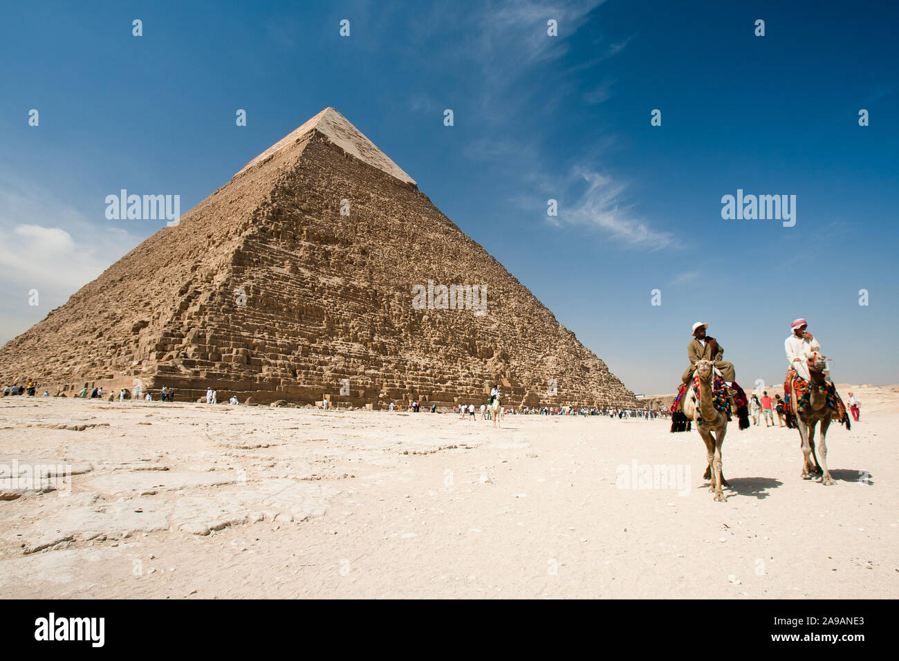Giza, Cairo, Egitto, 2 Maggio 2008: la piramide di Khafre torreggia su turisti e due uomini a cavallo di cammelli sull'altopiano di Giza vicino al Cairo, Egitto. Foto Stock