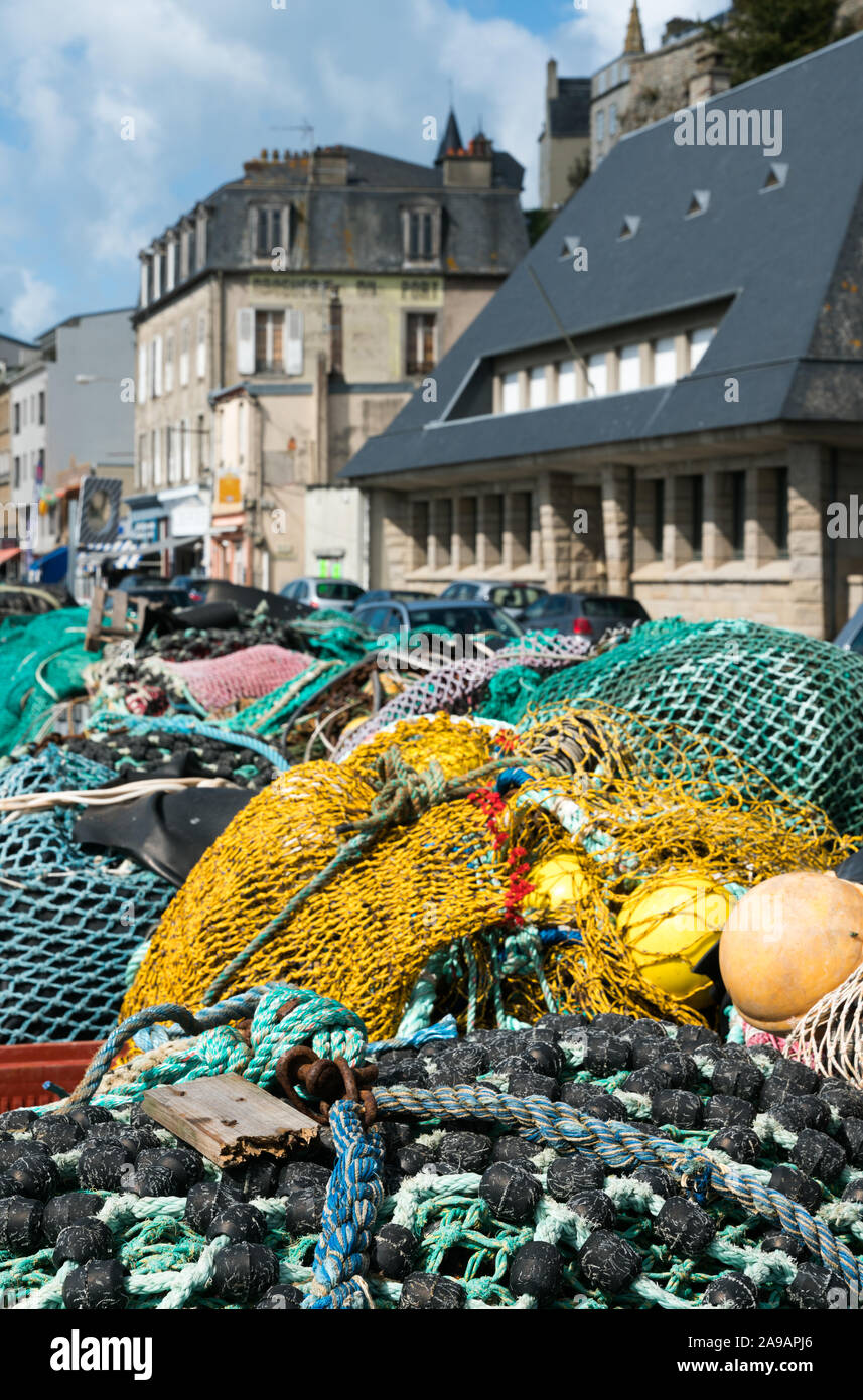 Una vista ravvicinata del gran mucchio di diverse reti da pesca utilizzati per la pesca di mare e la pesca a strascico la posa sul molo di un francese di villaggio di pescatori Foto Stock