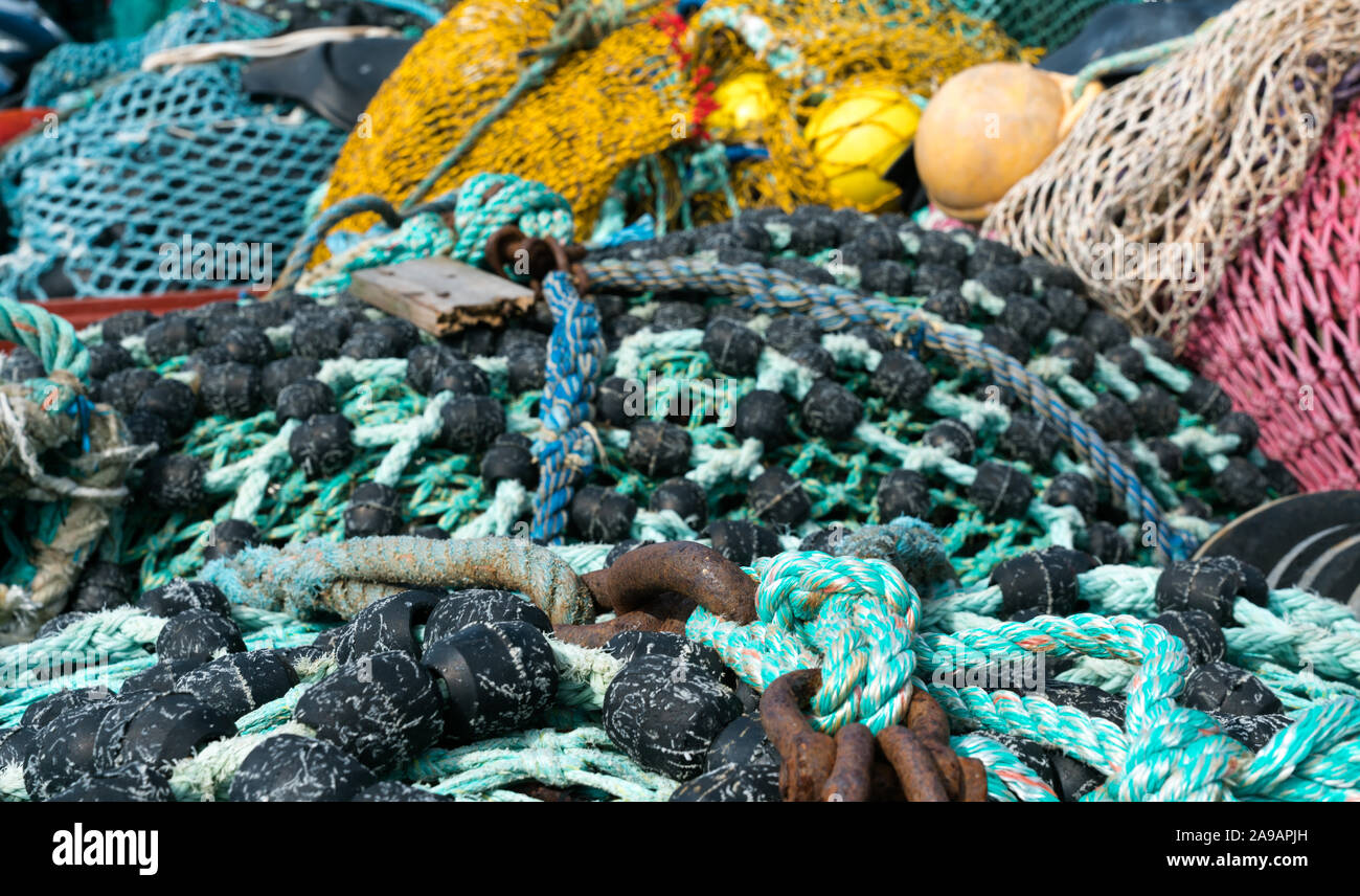 Un gran mucchio di diverse reti da pesca utilizzati per la pesca di mare e la pesca a strascico la posa sul dock Foto Stock