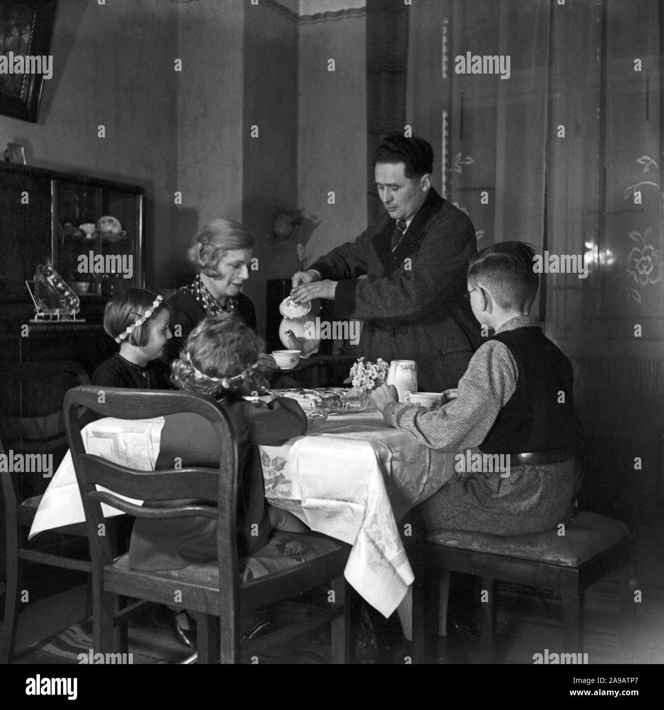 Una famiglia seduta al tabele, avente caffè, Germania 1930s. Foto Stock