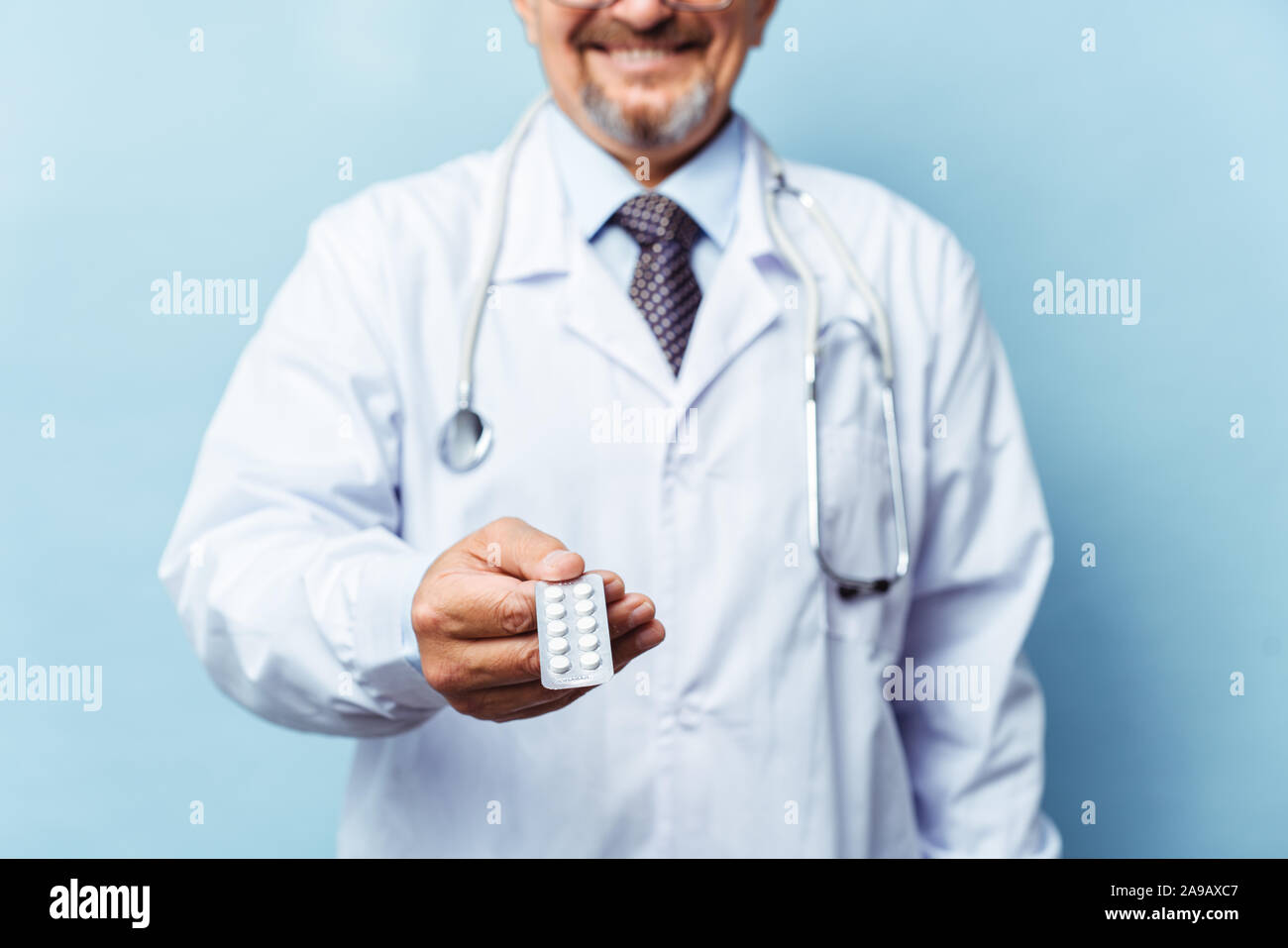 Medico dando pillole medicinali. su sfondo blu. Il concetto di medicina, farmacologia, healthcare. Foto Stock