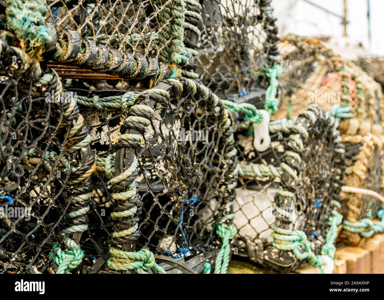 Lobster Pot impilate con la parete del porto Foto Stock