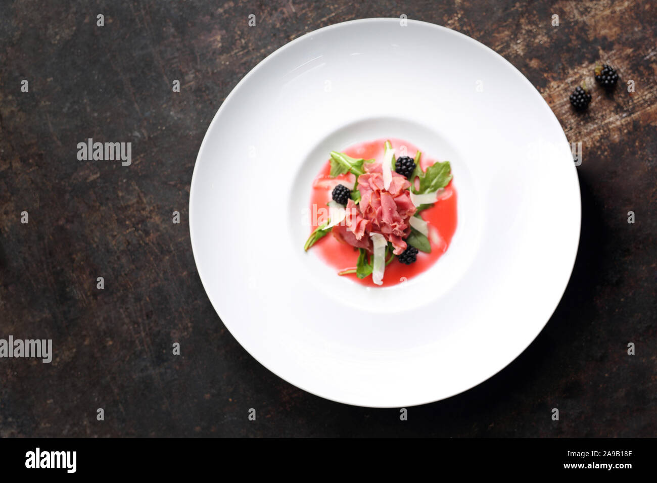 Carpaccio di manzo servita su lampone e mousse di Blackberry. Antipasto Foto Stock