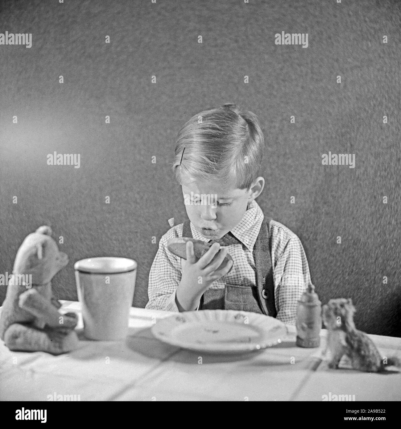 Un ragazzino di mangiare il suo pane e burro, Germania 1951 Foto Stock