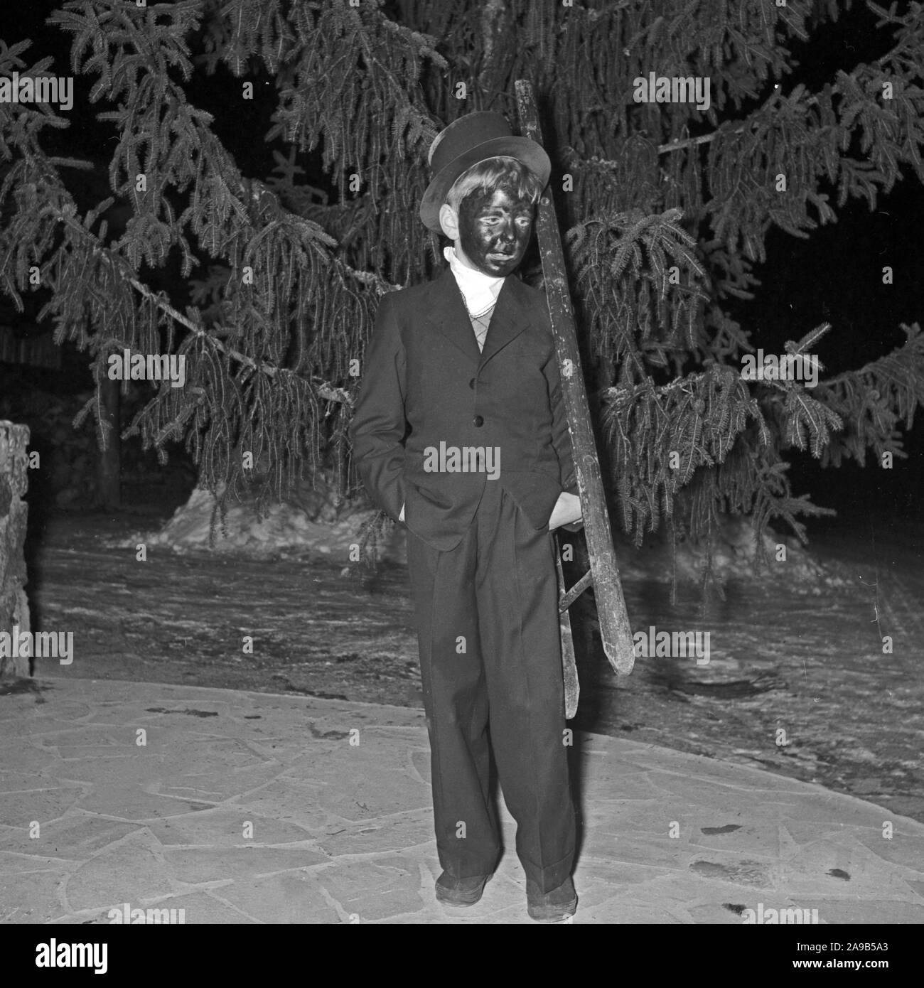 Un piccolo ragazzo giocando la spazzacamino come un simbolo per fortuna per il nuovo anno, Germania 1955 Foto Stock