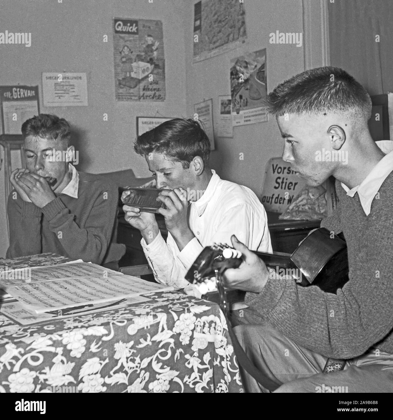 Tre ragazzi con armonica e gutar giocare i loro brani preferiti, Germania 1956 Foto Stock