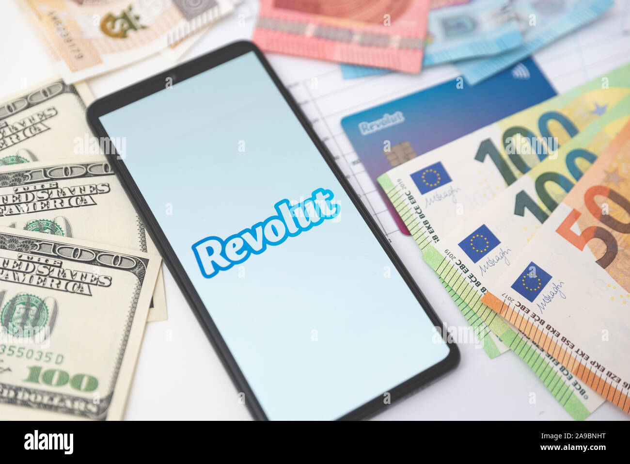 Wroclaw, Polonia - Nov 06, 2019: Revolut logo della banca sullo schermo dello smartphone accanto alle banconote. Revolut Ltd è un regno unito financial technology company che di Foto Stock