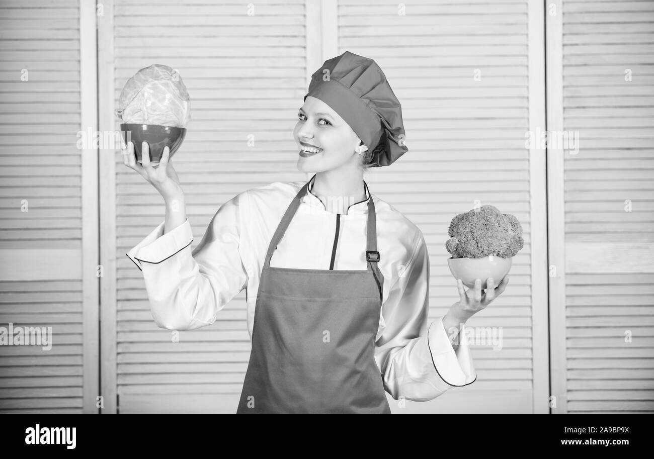 Dietologia e vitamina. Cucina culinaria. Cuocere nel ristorante, uniforme. chef professionale per la cottura in cucina biologica e vegetariana. donna felice ama il cibo sano. broccoli o cavolo. scelta giusta. Foto Stock