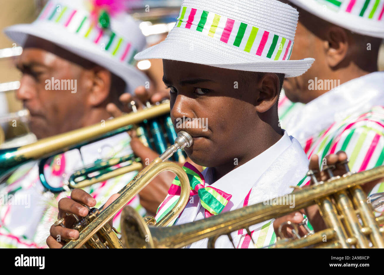 Razza mista boy suonare la tromba, Bugle, strumento musicale in una banda a una street parade festa di carnevale a Cape Town, Sud Africa sul Nuovo Anno Giorno Foto Stock