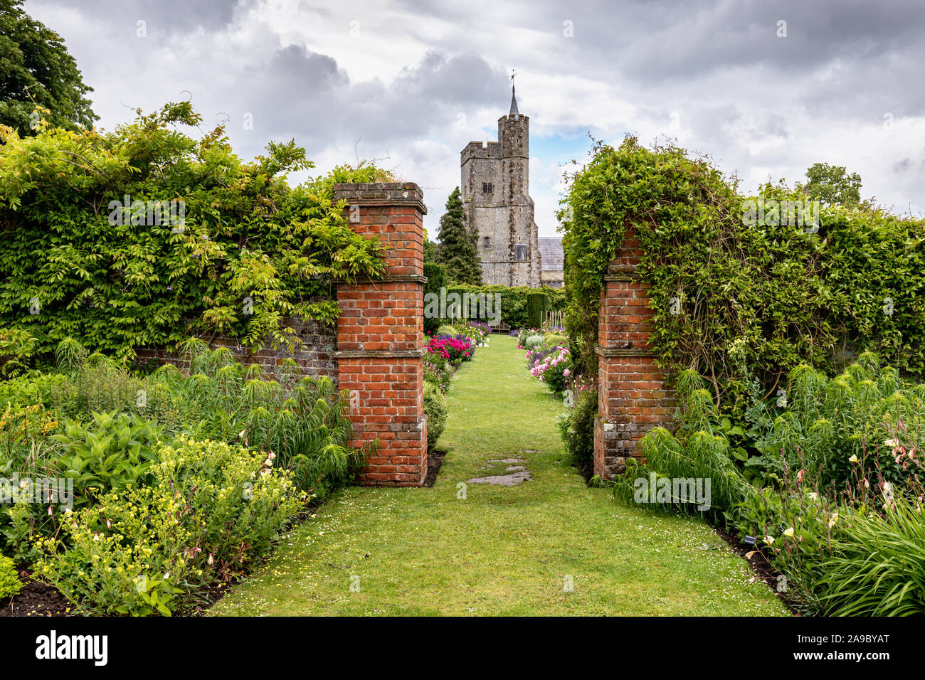 La Chiesa di Santa Croce vista da giardini murati a Goodnestone Park, Goodnestone, Dover, Kent, Regno Unito Foto Stock