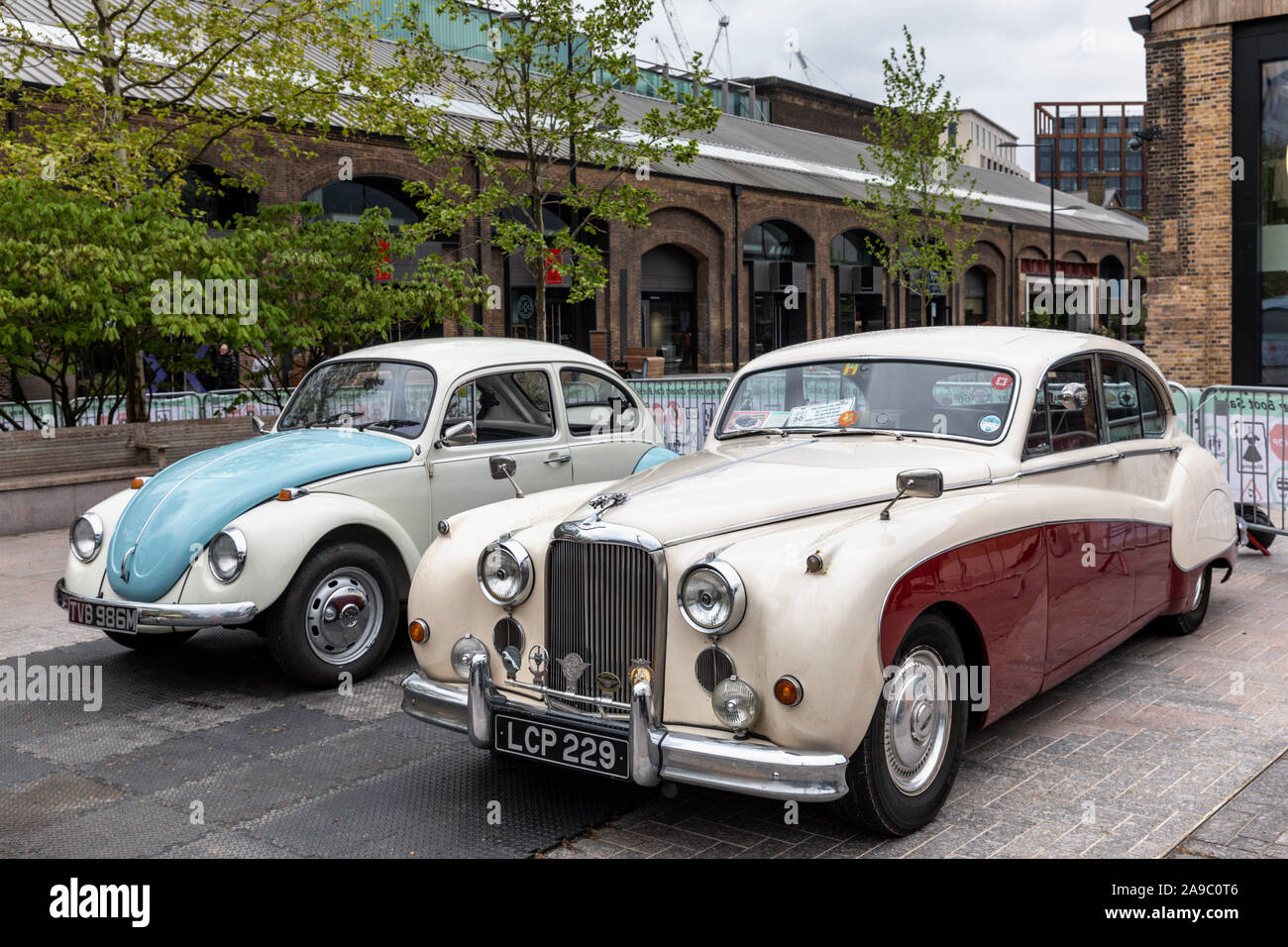 Due auto d'epoca, un 1959 Jaguar Mk IX e 1973 VW Beetle, London Classic Car Boot Vendita, King's Cross, London, Regno Unito Foto Stock