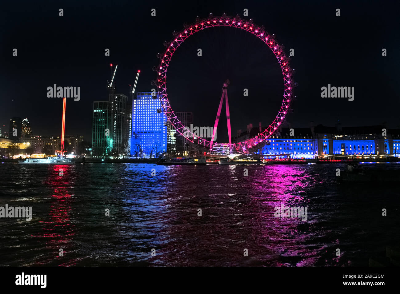 Il London Eye di notte rosa illuminato Foto Stock