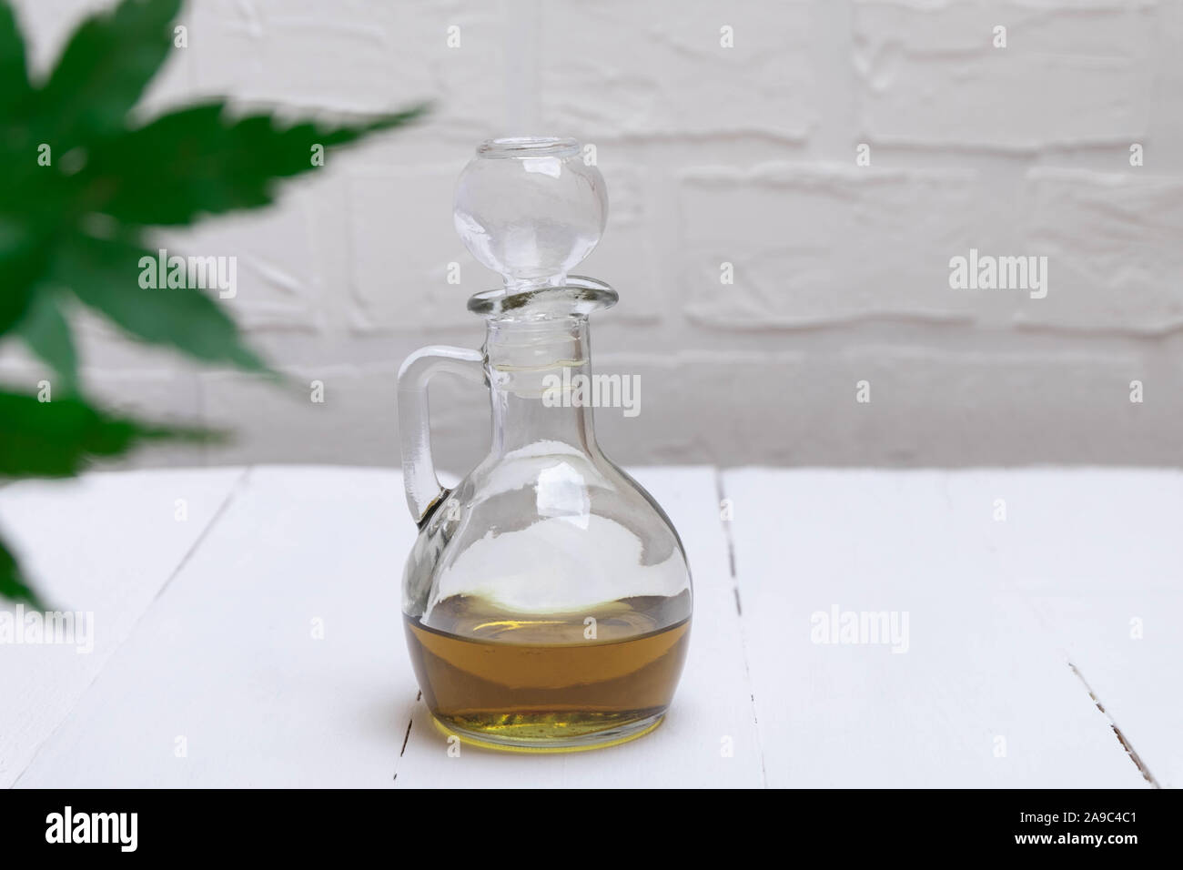 CBD olio di cannabis in un vaso sul tavolo bianco Foto Stock