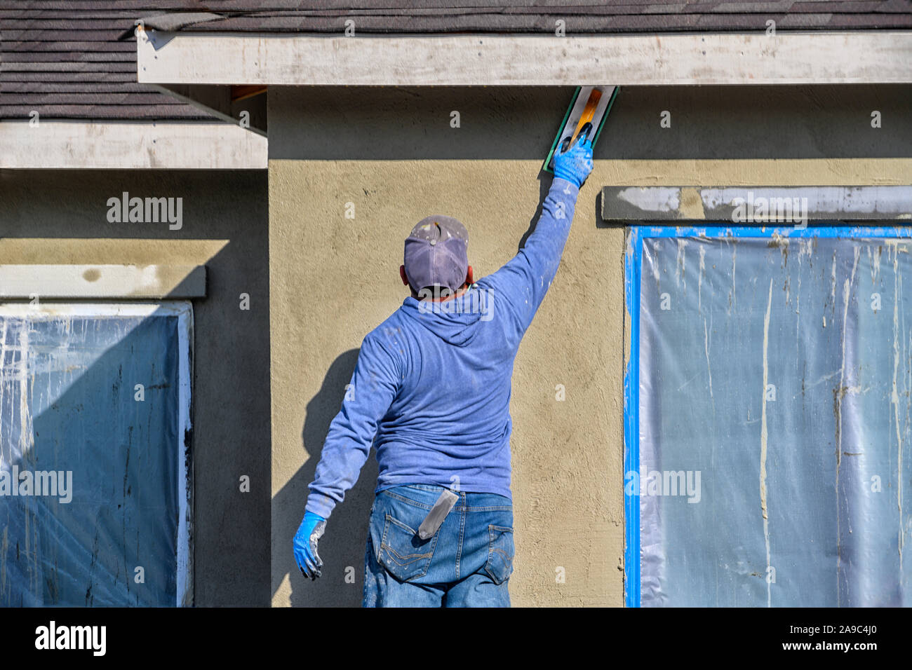 Rinnovo a casa. lavoratore edile mettendo intonaco decorativo sull'esterno della casa Foto Stock