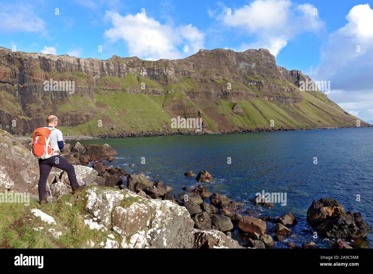 L'uomo prendendo nella splendida costa frastagliata sulla Isle of Mull. Queste scogliere remoto chiamato Binnein Gorrie sono conosciuto localmente come 'Gorrie's Leap' Foto Stock