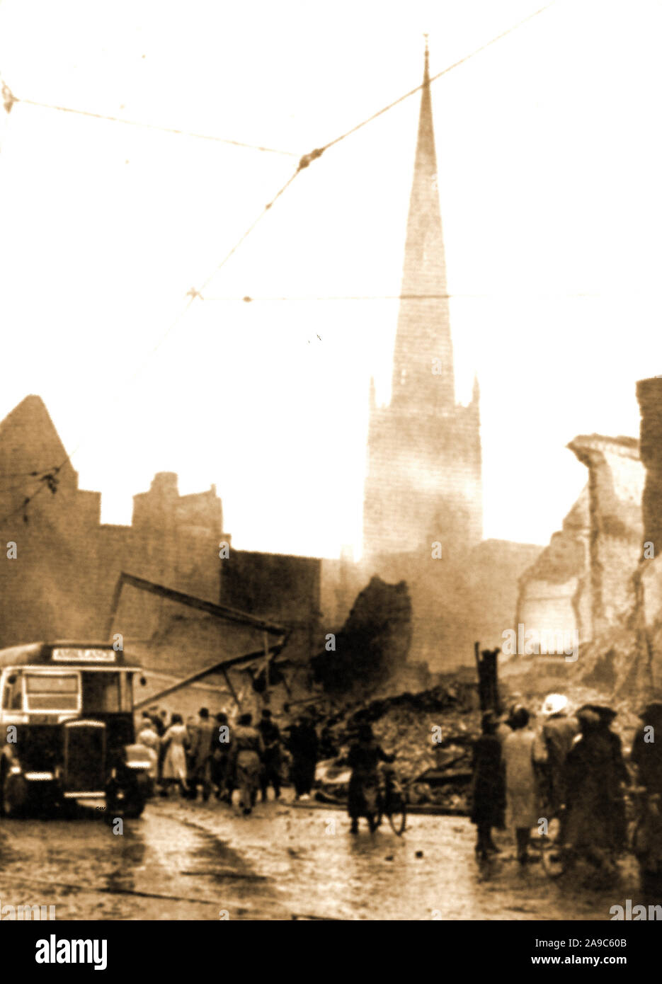 Durante la Seconda guerra mondiale - un bus essendo utilizzato come un ambulanza dopo i devastanti bombardamenti raid su Coventry Regno Unito nel 1941 (Coventry Blitz). Chiesa della Santa Trinità si innalza al di sopra di una scena di devastazione totale. Foto Stock