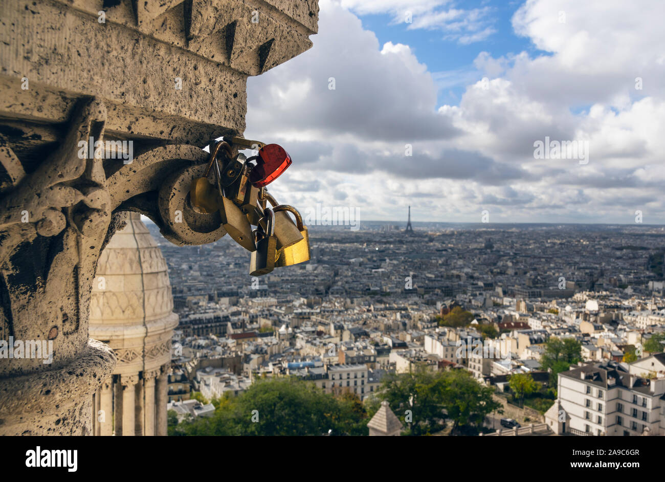 Alcuni lucchetti, uno a forma di cuore, attaccato alla Basilica del Sacro Cuore. In vista dello sfondo di Parigi Foto Stock