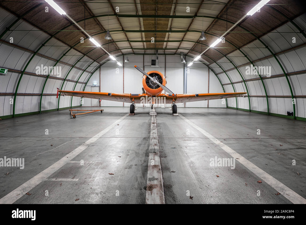 Singolo aeromobile a turboelica nel grande hangar. Un piccolo aereo in hangar sulla riparazione Foto Stock