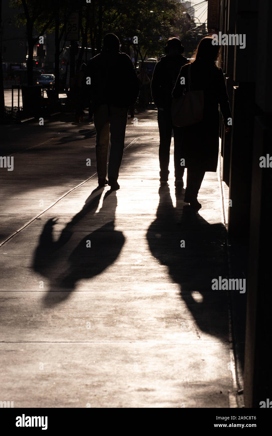 Irriconoscibile la gente che camminava sul New York City marciapiede con luci e ombre. Copia dello spazio disponibile. Foto Stock