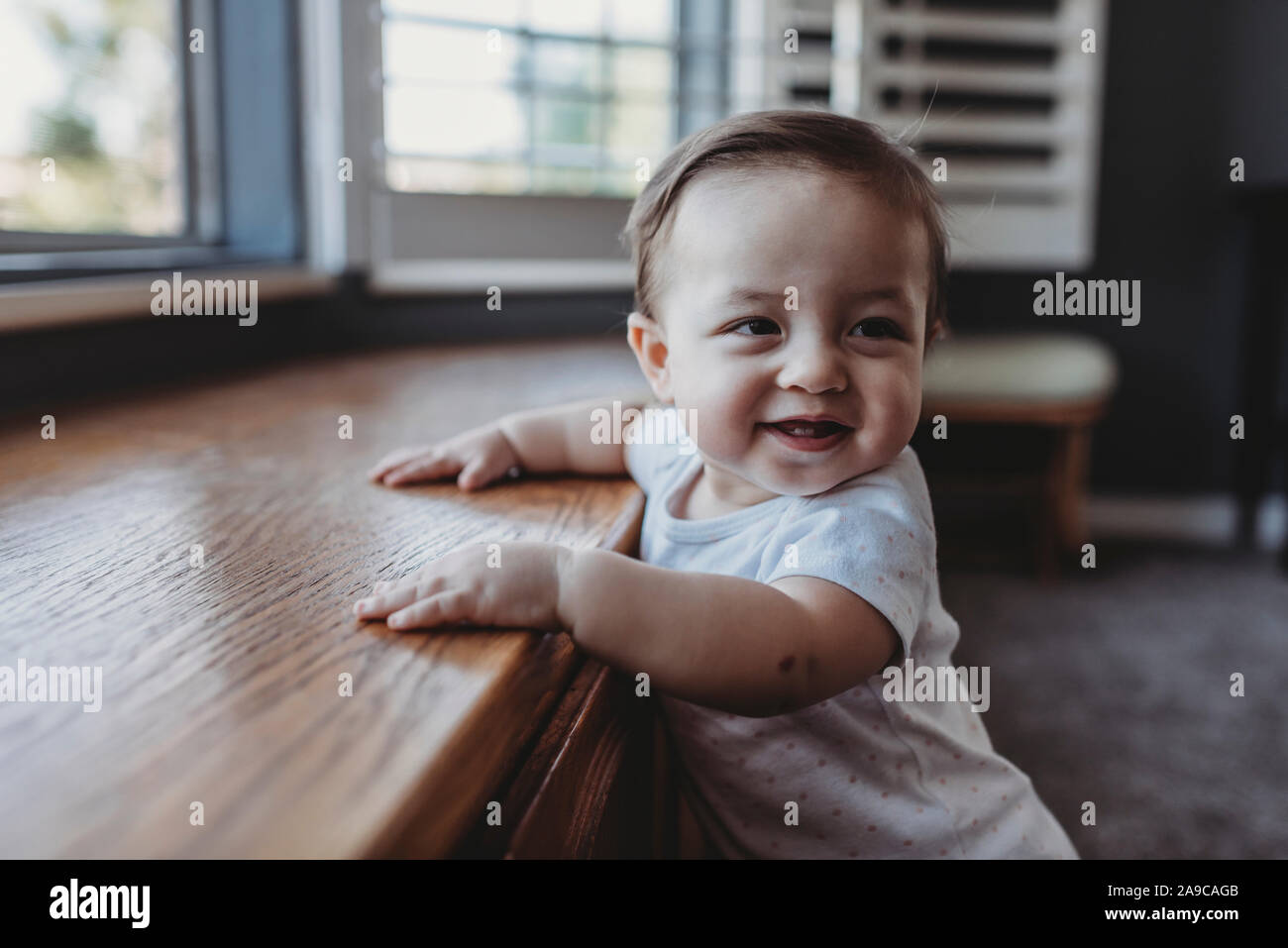 Bambino sorridente con due denti in piedi dalla sede della finestra Foto Stock