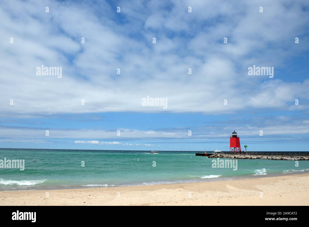 Paesaggio con Clear Lake, faro rosso, spiaggia di sabbia, pietra Pier Foto Stock