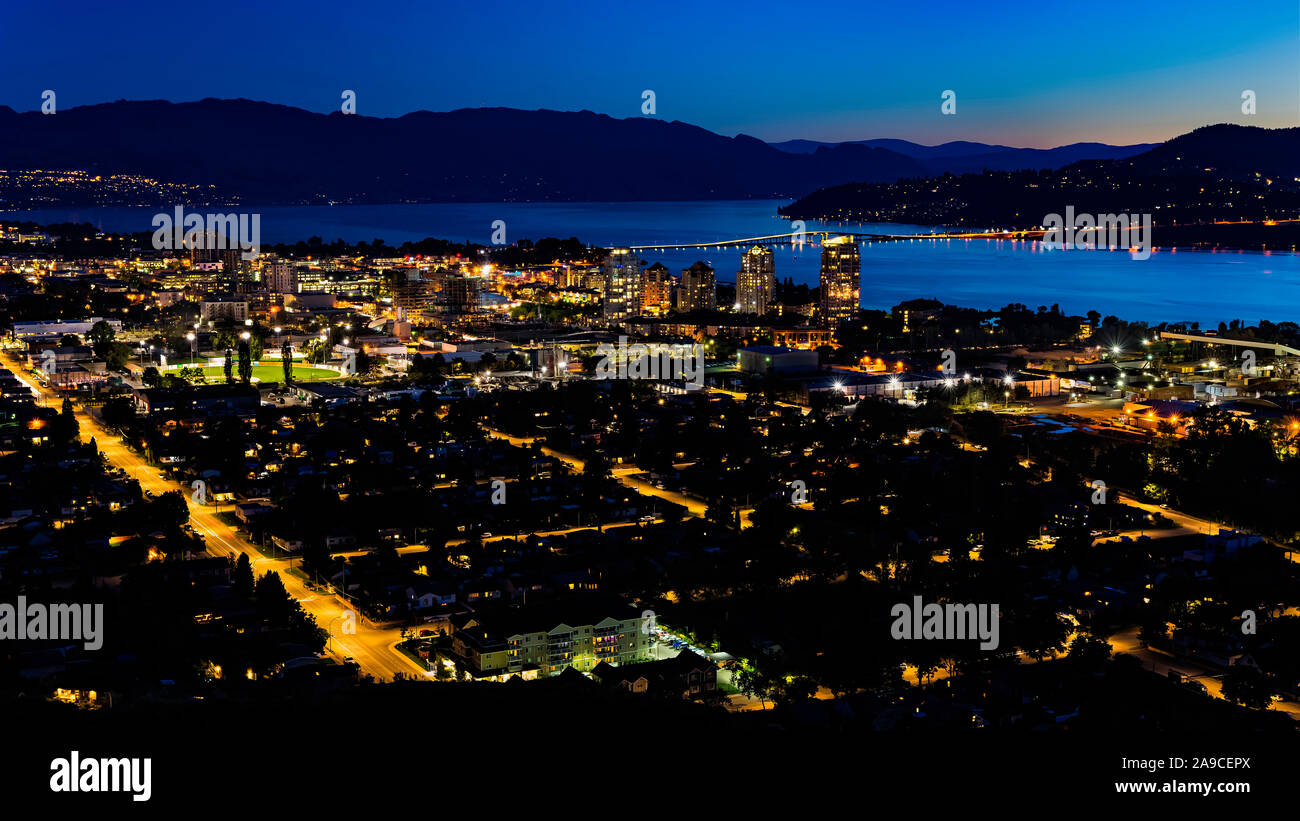 Un tempo di notte vista di Kelowna British Columbia skyline e Lago Okanagan dalla montagna di Knox al blue ora Foto Stock