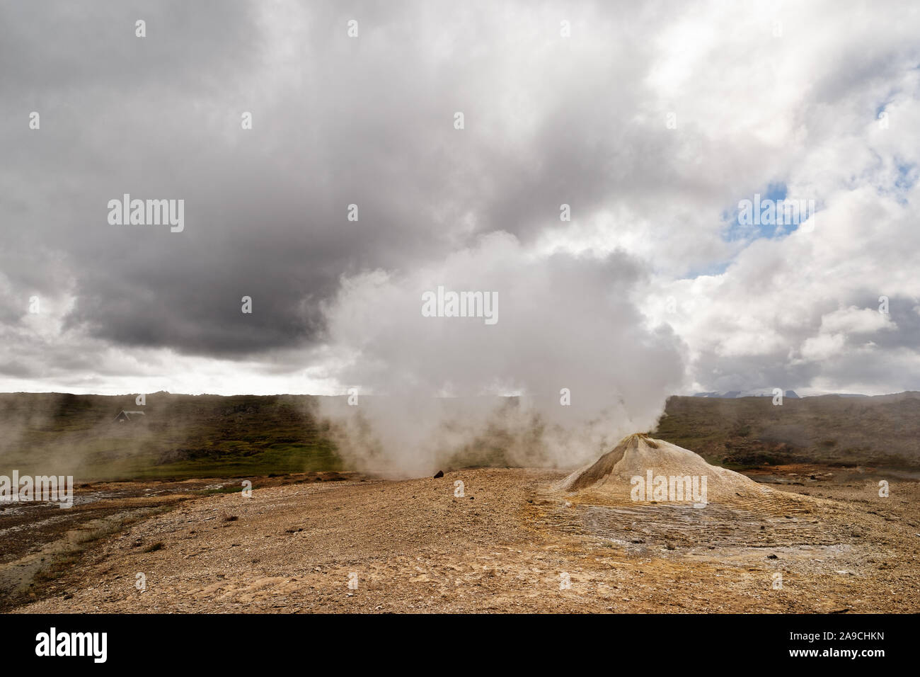Paesaggio vulcanico con una grande fumarola che emette un sacco di vapore, cielo contrastante con un po' di blu così come il bianco e il grigio nuvole - Posizione: IC Foto Stock