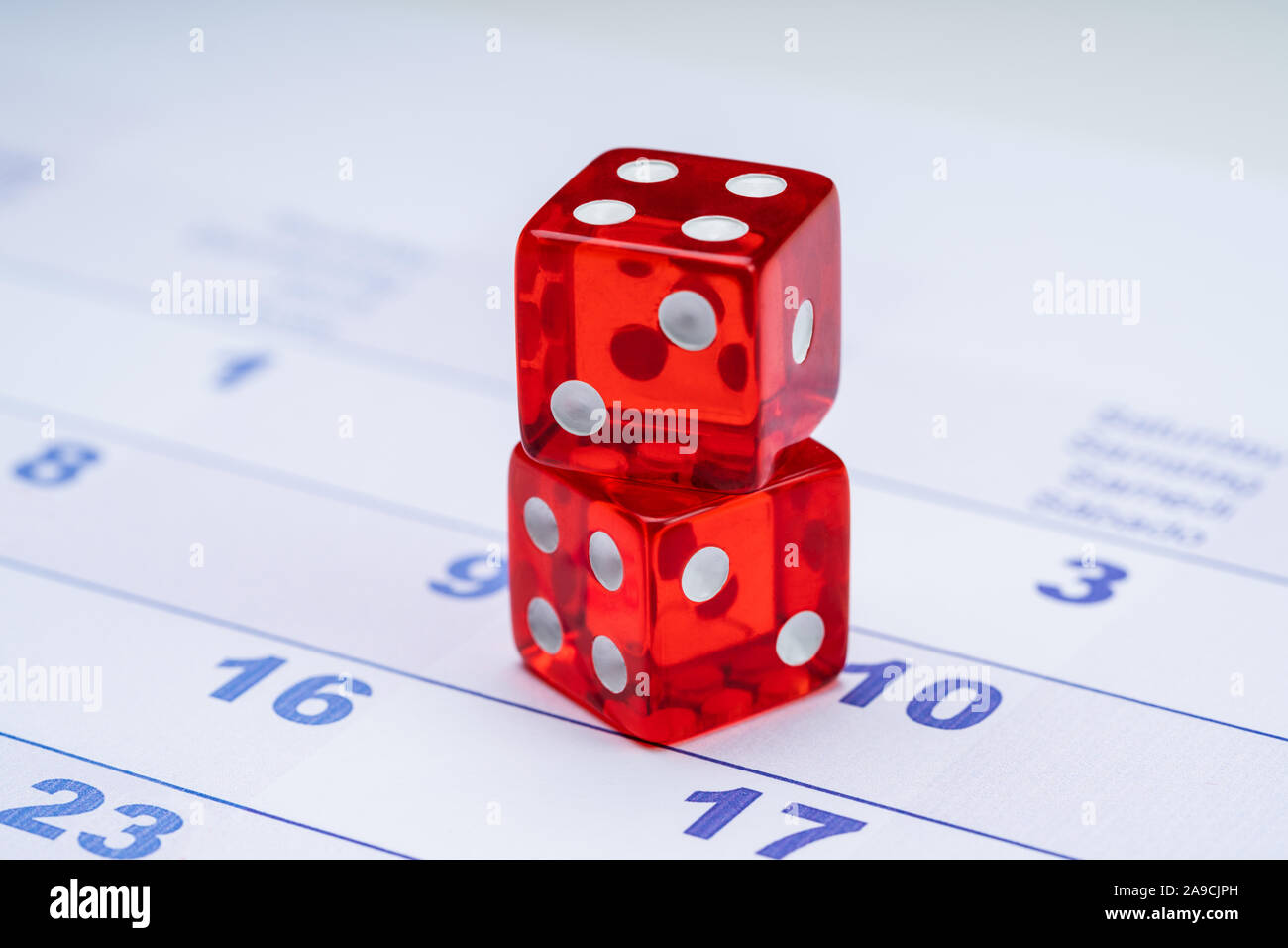 Close-up di traslucida a due dadi rossi sul calendario Foto Stock