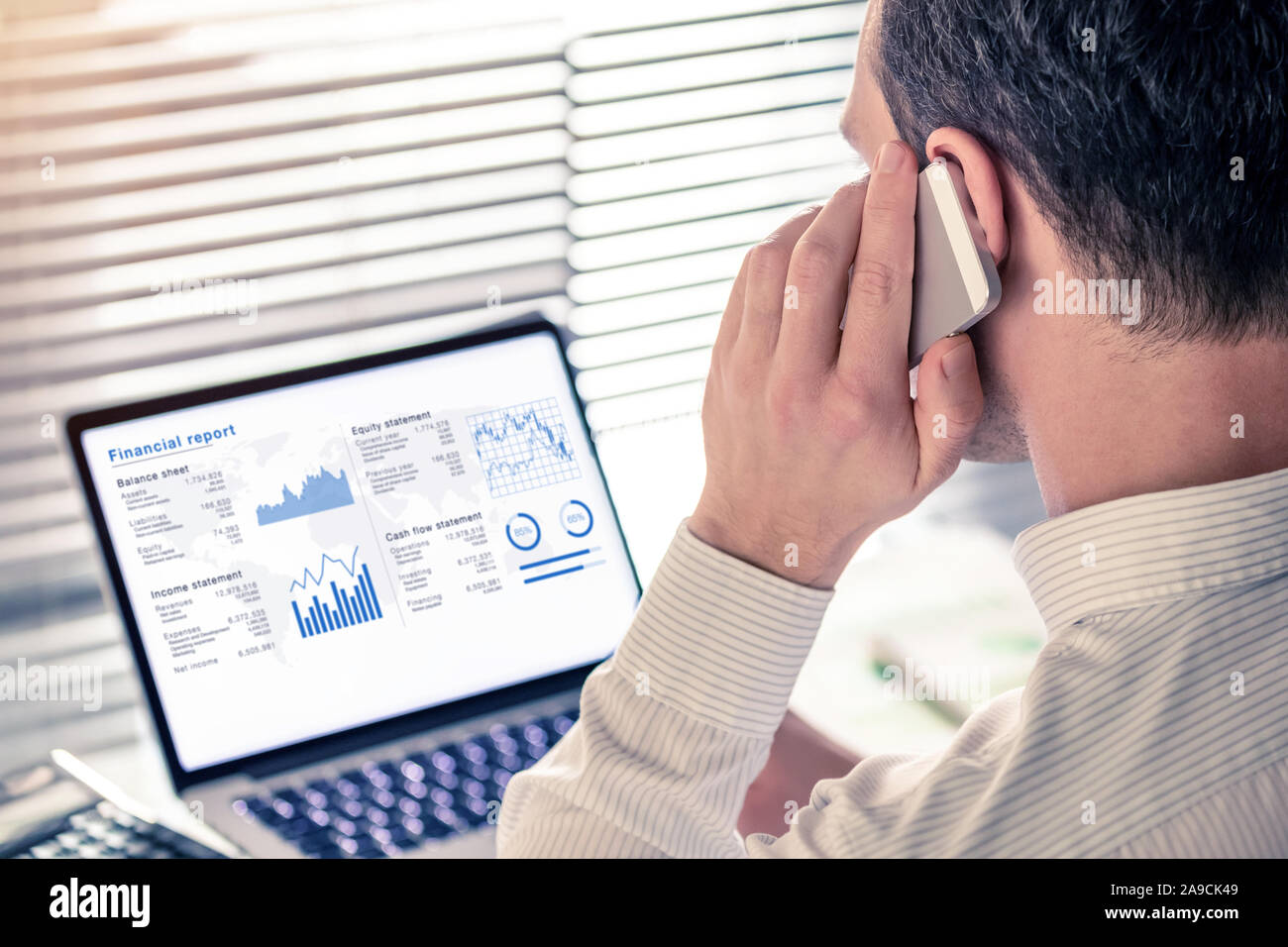 Senior executive manager analizza una relazione finanziaria sul computer in ufficio e chiamando al telefono, lavorando con operazioni di dati e KPI: equilibrio sh Foto Stock