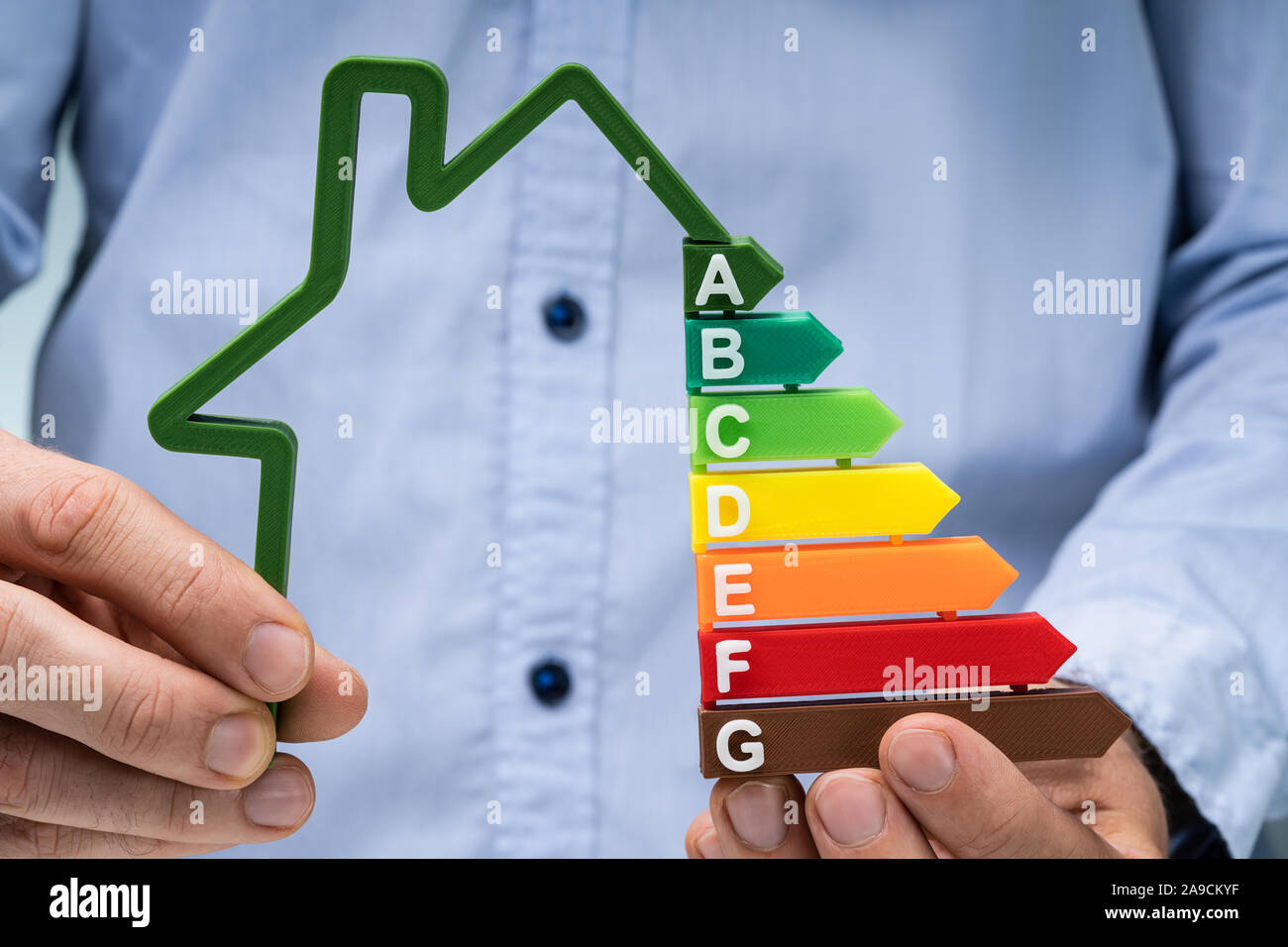La sezione centrale della mano di una persona azienda Green House Efficienza Energetica grafico Foto Stock