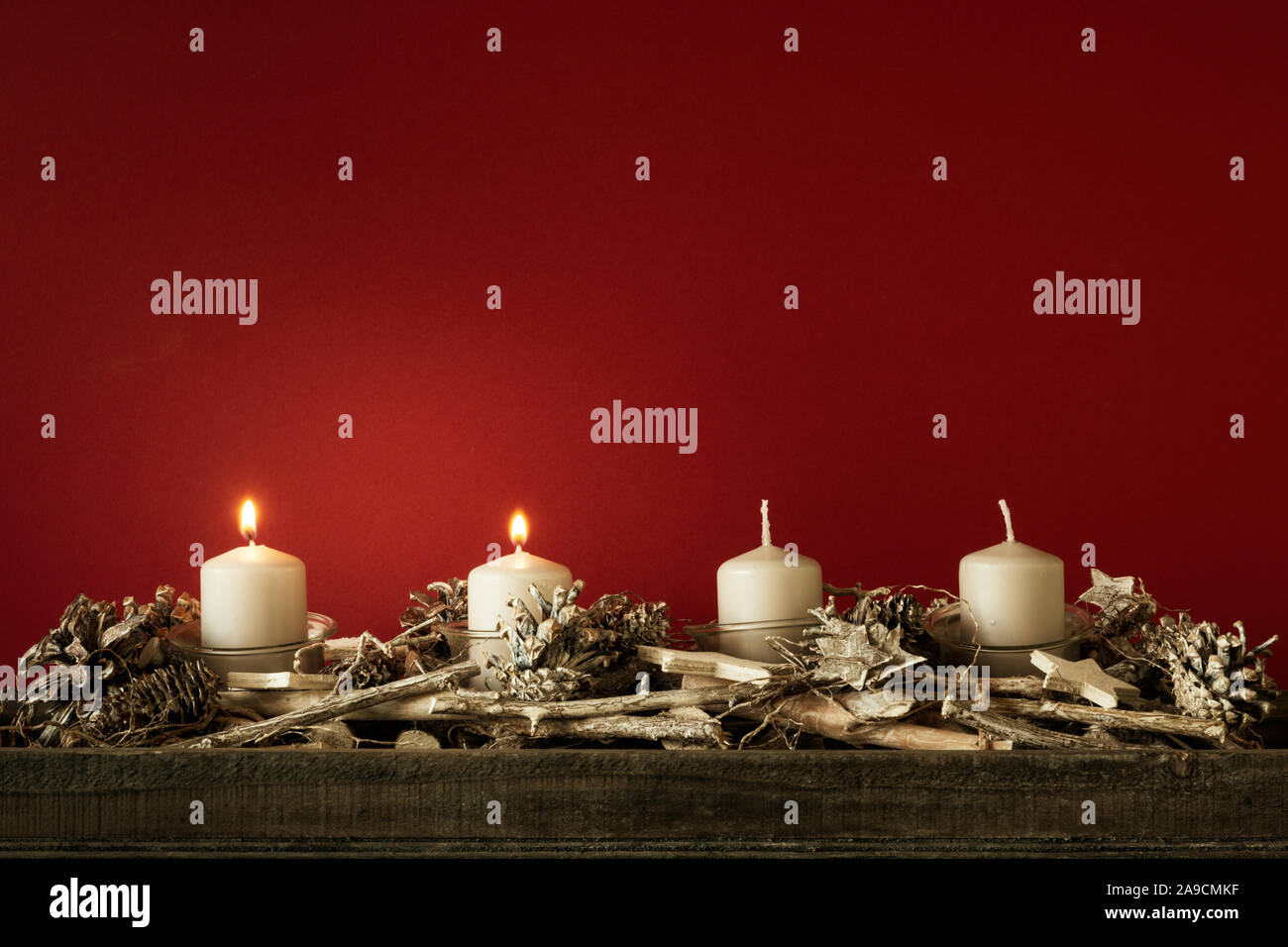 Il tempo di avvento due candele accese con sfondo rosso per i tuoi contenuti Foto Stock