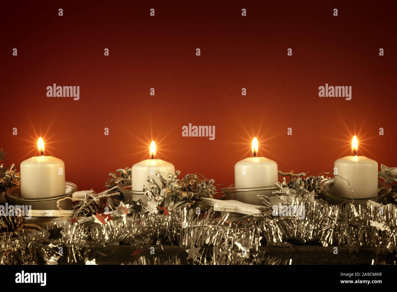 Il tempo di avvento quattro candele accese con sfondo rosso per i tuoi contenuti Foto Stock
