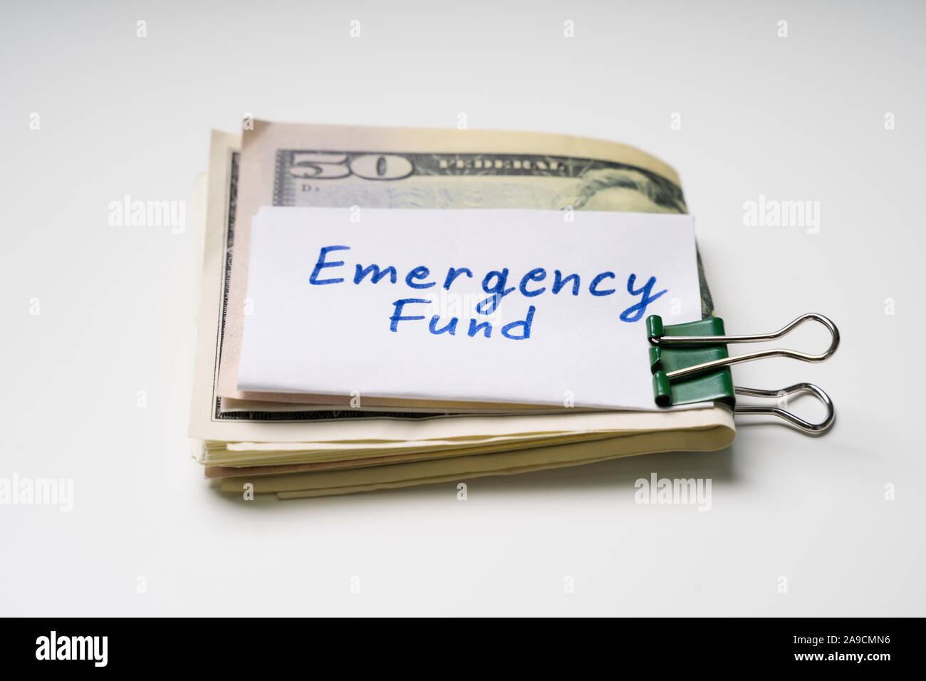 Carta nera fascetta ripiegata con cinquanta dollari banconota e fondo di emergenza del testo su un foglio di carta Foto Stock