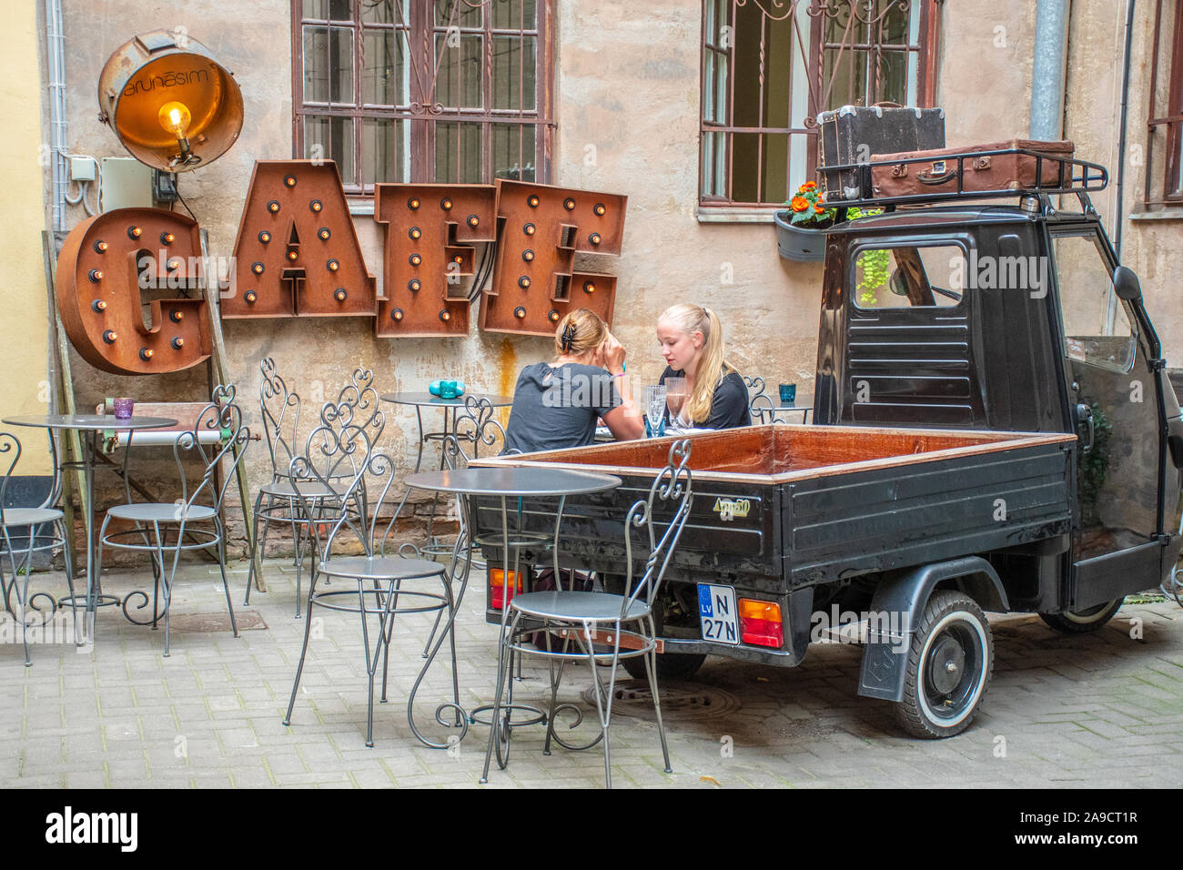 Due capelli biondi Ragazze bere al tavolo in una accogliente caffetteria in Riga old town, Lettonia Foto Stock