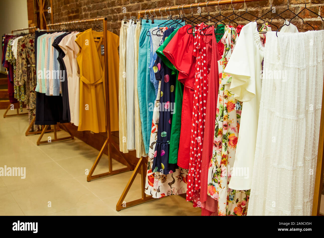 Colorata collezione di capi di abbigliamento femminile appeso su un rack. Foto Stock