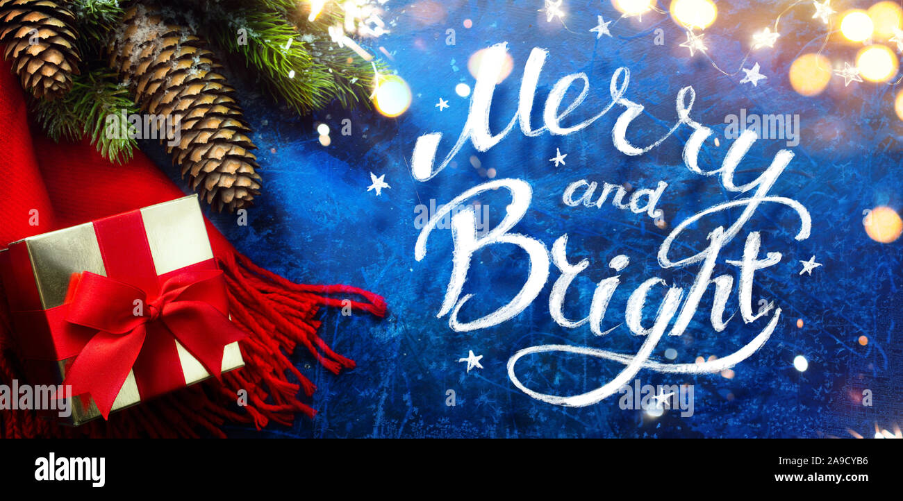 Arte allegro e luminoso Natale e Felice Anno Nuovo biglietto di auguri festivi backdropwith decorazioni natalizie e del regalo di festa su sfondo blu Foto Stock