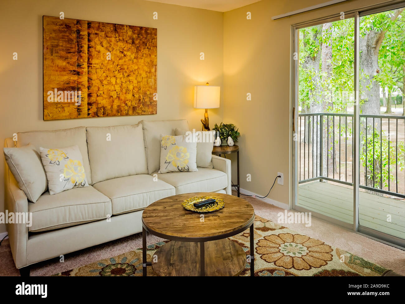 Un appartamento soggiorno è dotato di una porta a vetri scorrevole che conduce al balcone a Boschi di autunno appartamento case in Mobile, Alabama. Foto Stock