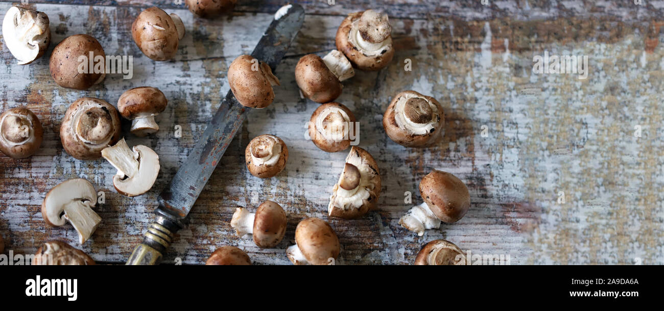 Royal champignon e coltello su una superficie in legno. Rosolare gli champignon. Messa a fuoco selettiva. Macro. Foto Stock