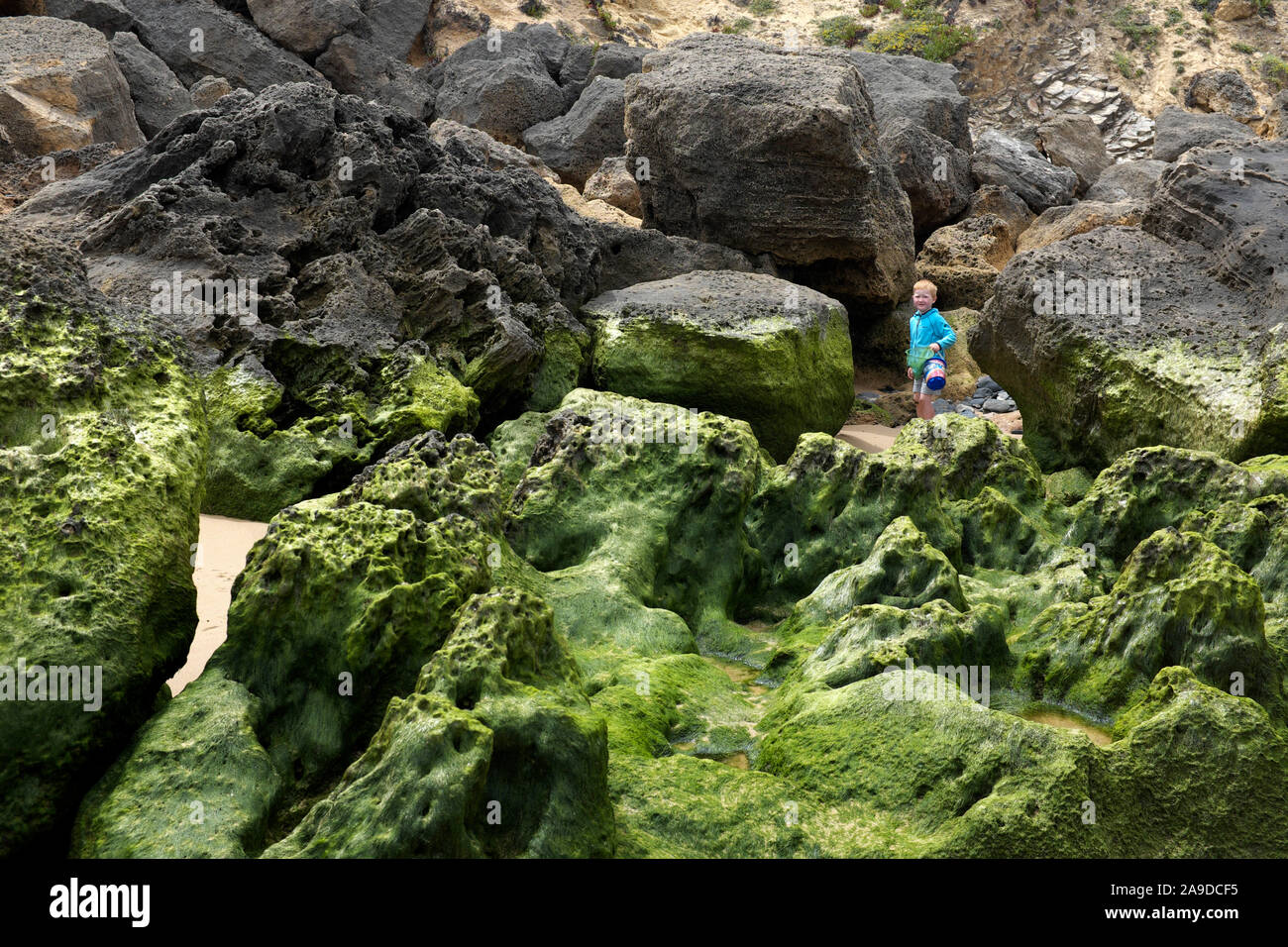 Praia de Monte Clerigo, ragazzo con benna giocando al mare Foto Stock