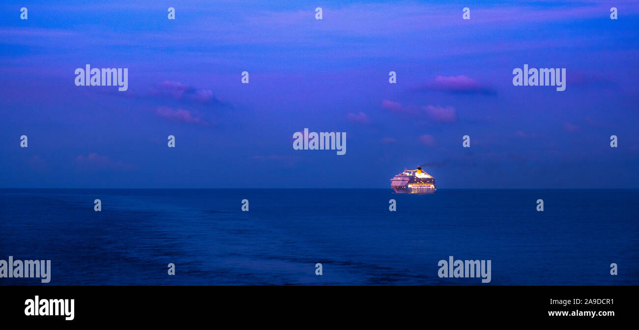La nave di crociera con illuminazione completa all'alba sul mare Mediterraneo Foto Stock