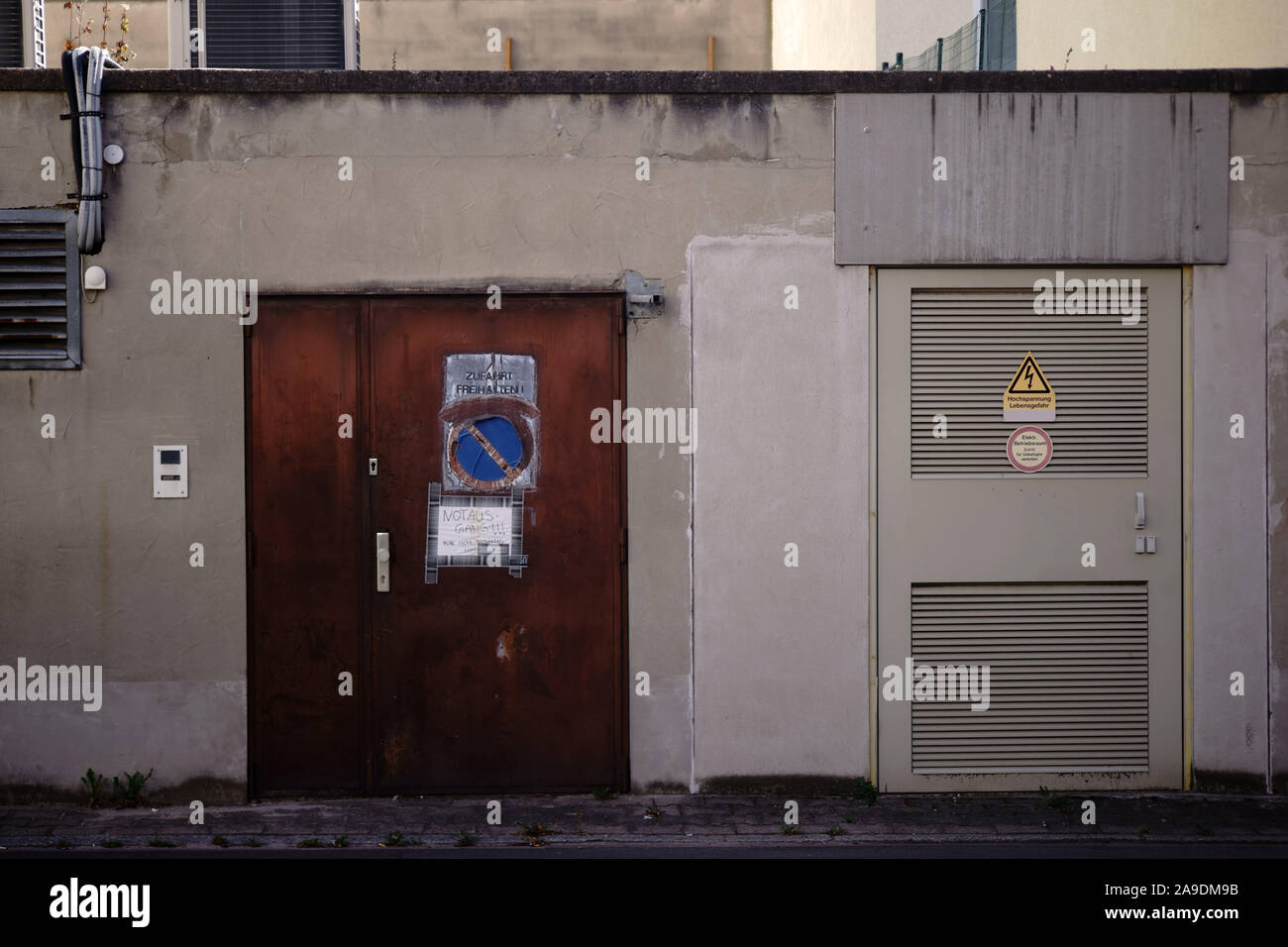 Il cortile di un edificio aziendale con un interruttore una casa o una ad alta tensione con un segnale di avvertimento, attenzione ad alta tensione. Foto Stock