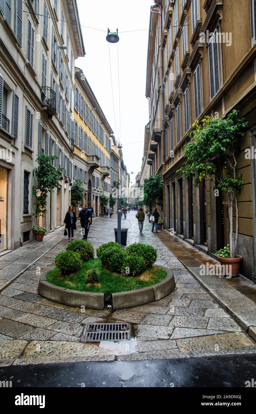 Italia, Milano - Ocrober 7, 2014: Strada tra antiche case con pedoni e piante verdi Foto Stock