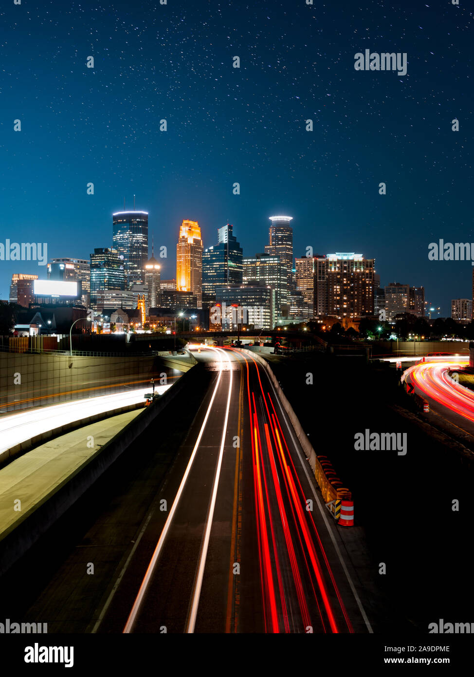 Sentieri di luce dalle vetture che vanno in e fuori della città di Minneapolis Foto Stock
