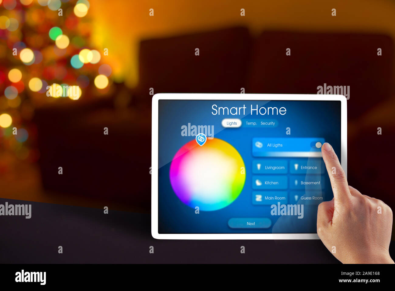 Casa intelligente di controllo luci su un tablet durante le vacanze con una mano Foto Stock