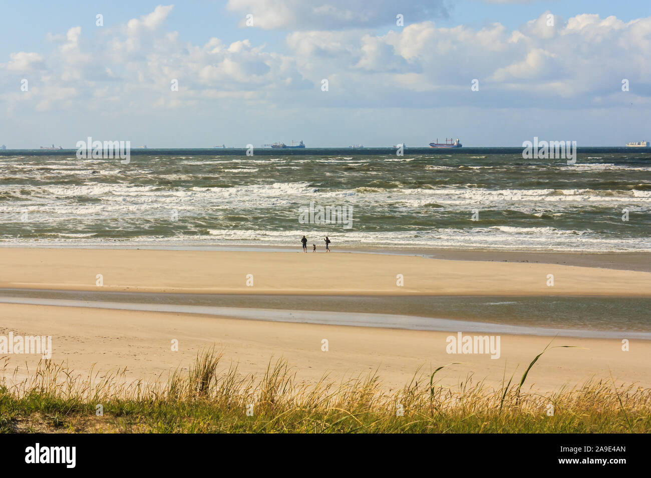 Una famiglia passeggiate sulla spiaggia di Wangerooge e osserva le navi all'orizzonte, Foto Stock