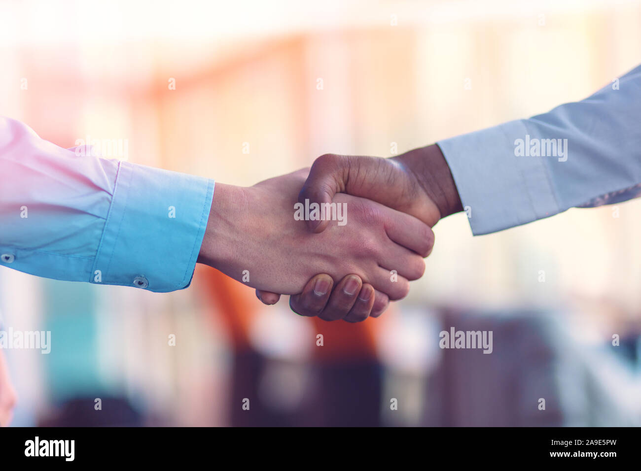 Stretta di mano tra africani e di un uomo caucasico. Foto Stock