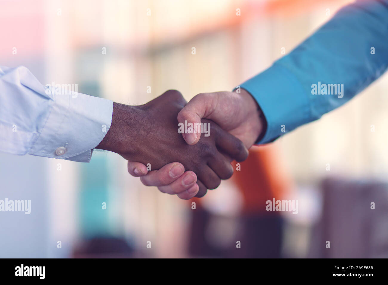 Stretta di mano tra africani e di un uomo caucasico. Foto Stock