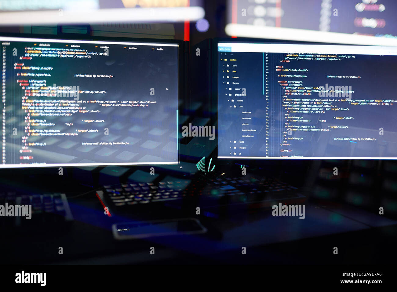 Immagine di due monitor di computer di installare il nuovo software in ufficio scuro Foto Stock