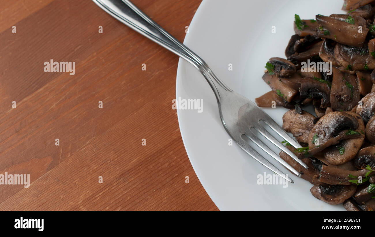 Saltata di funghi champignon con prezzemolo tritato, 16:9 Foto Stock